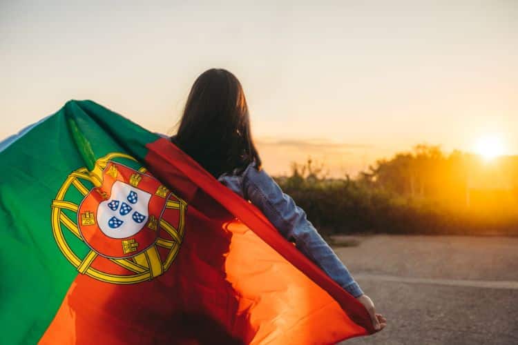 Daughter of a Portuguese man, seen from the back, holding the flag of Portugal.